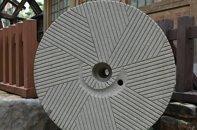 Circular stone mill wheel in a traditional setting, used for freshly milled flour
