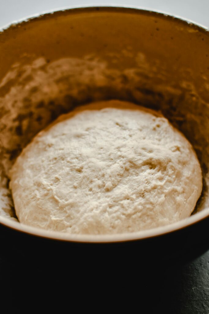 A close-up shot of raw dough in a bowl, showcasing texture and color.
